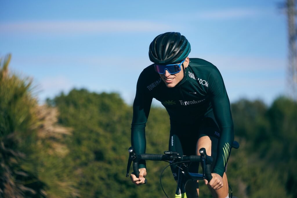 a man riding a bike down a road next to a forest